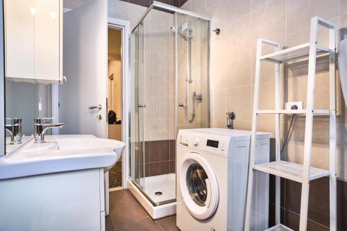 uma casa de banho com uma máquina de lavar roupa e um lavatório em La Voliera em Verona