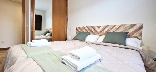 a bedroom with a large bed with towels on it at Apartamento I&F Colombres by Casas de Los Picos in Colombres