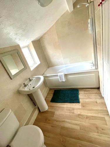 a bathroom with a toilet and a sink and a shower at Bedford town house in Bedford