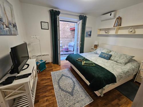 a bedroom with a bed and a desk with a television at Dubrovniks best views apartment from a spacious terrace in Dubrovnik