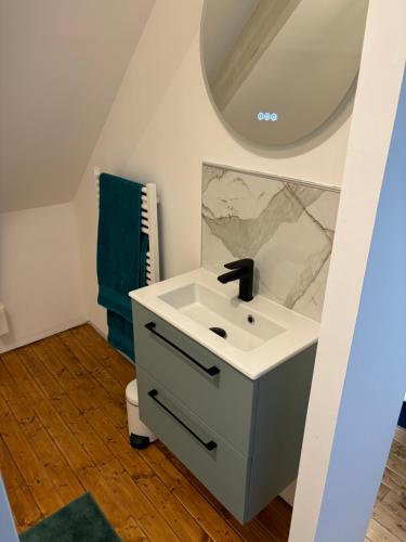 une salle de bain avec un lavabo et un miroir dans l'établissement Gîte Les Dorés Musis, à Carency