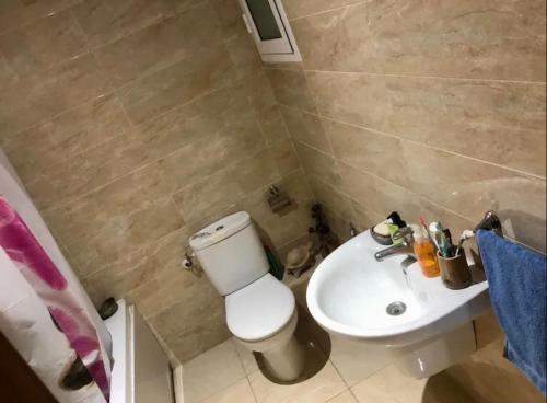 a bathroom with a white toilet and a sink at Suite privée dans un appartement à partager in El Aouina