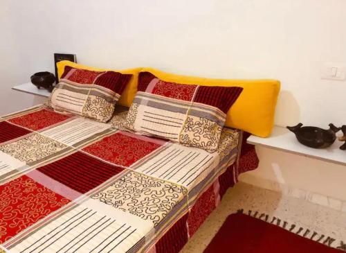 a bed with four pillows on top of it at Suite privée dans un appartement à partager in El Aouina