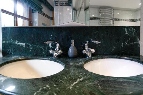 two sinks in a bathroom with two faucets at Villa22 Oetz in Oetz