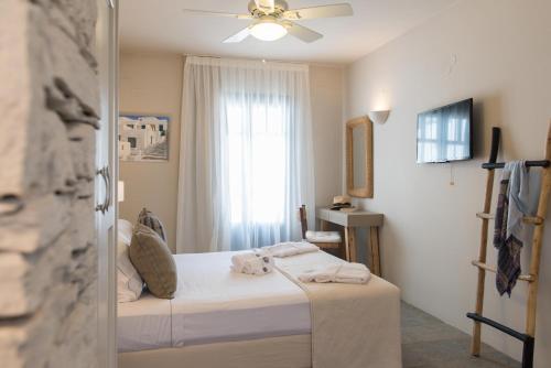 a bedroom with a bed and a window at Sifnos House - Rooms and SPA in Kamarai