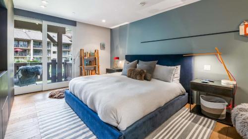 韋爾的住宿－Glades Chalet，一间卧室设有一张蓝色墙壁的大床