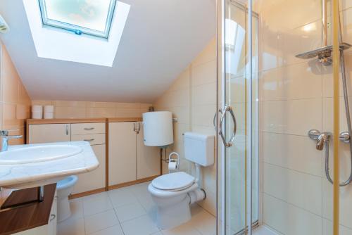 a bathroom with a toilet sink and a shower at Apartment Ruzmarinka with Spacy Terrace in Baška