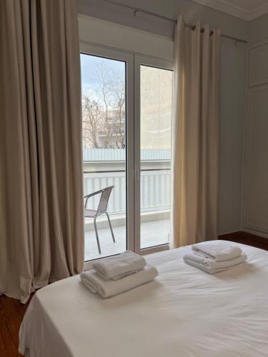 1 dormitorio con 1 cama y ventana con silla en Acropolis Luxury Apartments Parthenon view en Athens