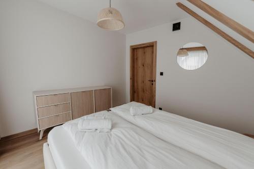 a bedroom with a white bed with two towels at To Je To apartamenty in Maniowy