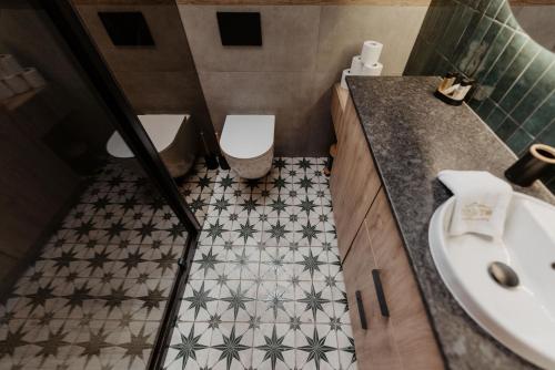 a bathroom with a toilet and a sink at To Je To apartamenty in Maniowy