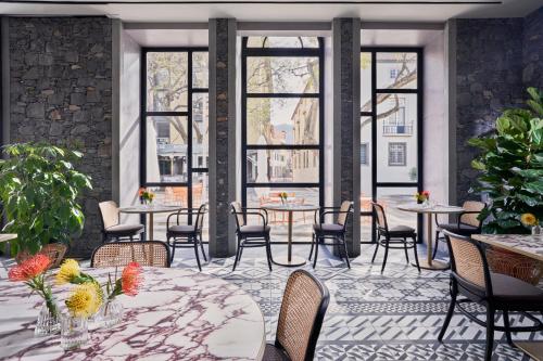 a restaurant with tables and chairs and windows at Barceló Funchal Oldtown in Funchal