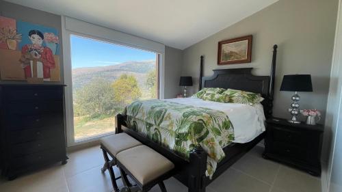 Casas del CastañarにあるMi Valle Ruralのベッドルーム1室(ベッド1台、大きな窓付)