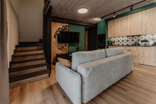 a living room with a couch and a staircase at To Je To apartamenty in Maniowy