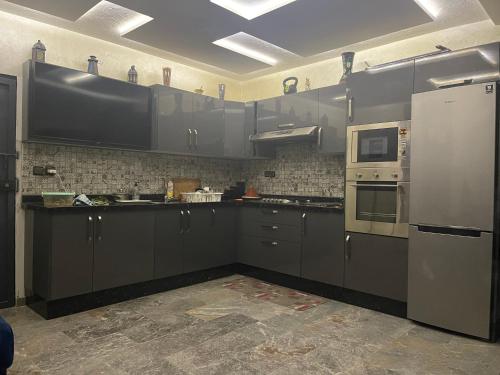 a kitchen with gray cabinets and a refrigerator at Riad Targante Takate 2 in Takkat