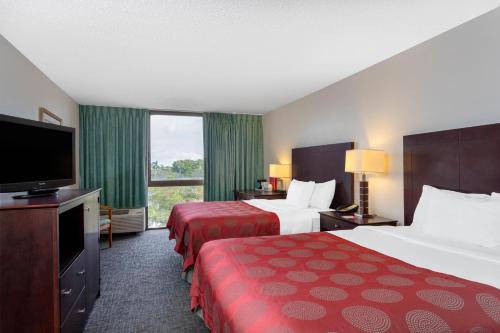 ein Hotelzimmer mit 2 Betten und einem Flachbild-TV in der Unterkunft 88 Palms Hotel & Event Center in West Palm Beach