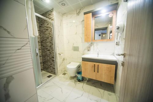 a bathroom with a sink and a toilet and a shower at OF UZUNGÖL APART OTEL in Of