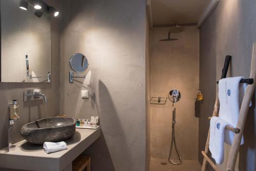 a bathroom with a sink and a shower at Sifnos House - Rooms and SPA in Kamarai
