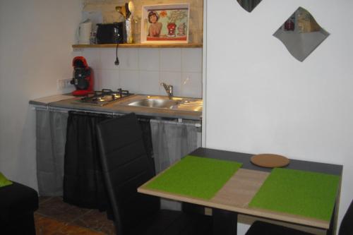 a small kitchen with a sink and a table at Le Poirier in Gordes