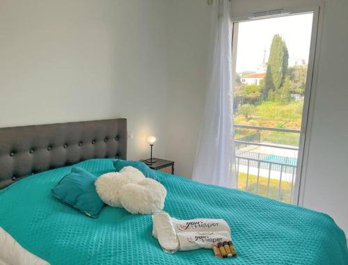 a stuffed animal laying on a bed with a window at Jardin Secret YourHostHelper in Antibes