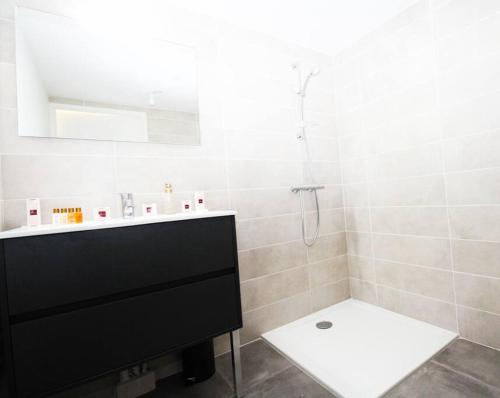 a white bathroom with a sink and a shower at Jardin Secret YourHostHelper in Antibes