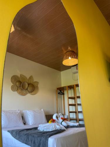 a bedroom with two beds and a yellow wall at Oka Pousada Atins in Atins