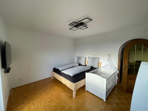 a bedroom with a bed and a tv and a crib at Meli's Zirbenbett Ferienappartment in Bernstein