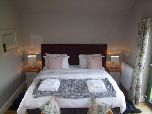 een slaapkamer met een bed met twee handdoeken erop bij Snowdrop Lodge in Errol