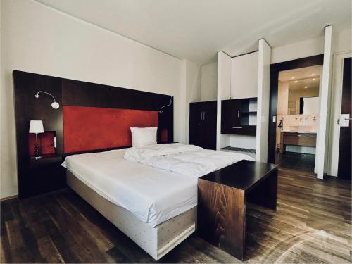 ein Schlafzimmer mit einem großen Bett und einem Schreibtisch darauf in der Unterkunft Hotel BRASSERIE in Erlangen