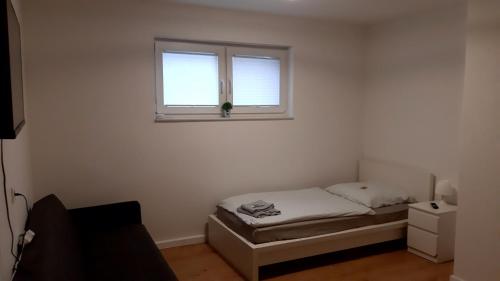 Habitación pequeña con cama y ventana en Unterkunft mit 5 Einzelzimmern, en Selm