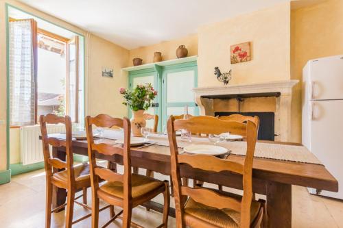 une salle à manger avec une table et des chaises et une cheminée dans l'établissement Maison chaleureuse à Éringes avec jardin et parking inclus, à Éringes
