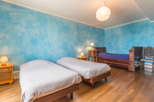 a bedroom with two beds and blue walls at Maison de 2 chambres avec jardin amenage et wifi a Eringes in Éringes