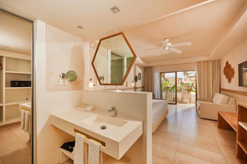 a bathroom with a sink and a bed and a mirror at Bahia Principe Grand Tulum - All Inclusive in Akumal