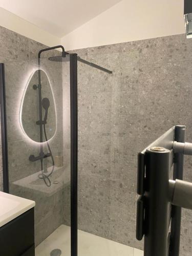 une douche avec une porte vitrée dans une salle de bain dans l'établissement Le Solférino toulouse centre, à Toulouse