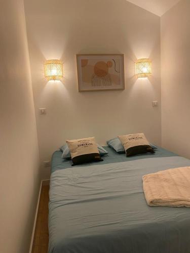 - une chambre avec deux lits et deux lumières sur le mur dans l'établissement Le Solférino toulouse centre, à Toulouse