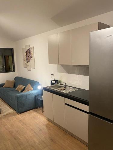 une cuisine avec un canapé bleu dans le salon dans l'établissement Le Solférino toulouse centre, à Toulouse