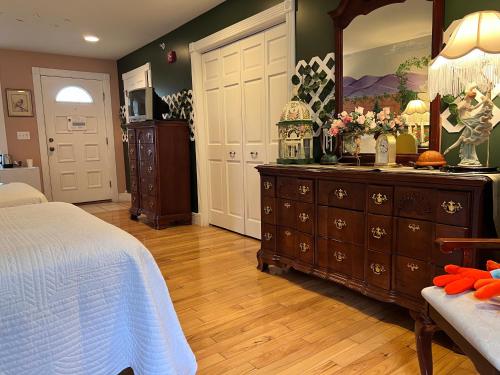 a bedroom with a bed and a dresser with a mirror at Mountain Quest Inn in Marlinton