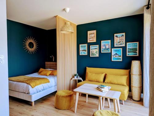 une chambre avec un lit et un mur bleu dans l'établissement GLAZIK - Studio - Lumineux - Parking, à Vannes