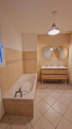 La salle de bains est pourvue d'une baignoire, d'un miroir et d'un lavabo. dans l'établissement LAMELINE, à Échenoz-la-Méline