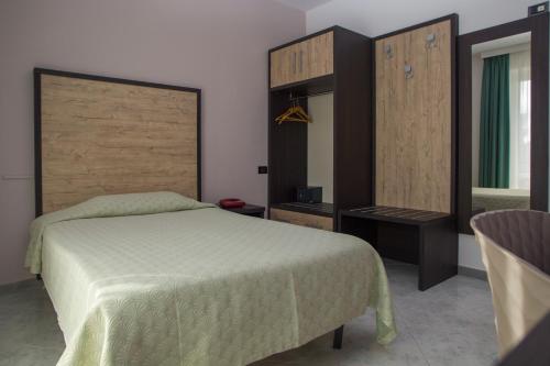 a bedroom with a bed and a wooden headboard at Hotel San Marco in Rionero in Vulture