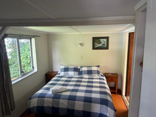 a bedroom with a blue and white bed and a window at Resolution Bay in Resolution Bay