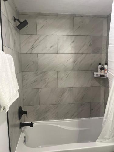 a bathroom with a white tub and a white towel at Beautiful 2 Bedroom Guest Suite in Leduc 11 mins to Edmonton Intl Airport, Free Wifi, Netflix ,Cable & Workstation in Leduc