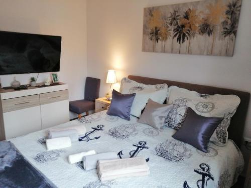 een slaapkamer met een bed met kussens en een televisie bij Holiday home Anima Mea, Zadar in Zadar