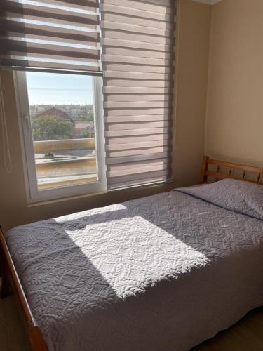a bedroom with a bed and a large window at Departamento La Serena por Días in La Serena