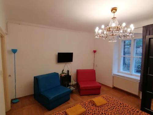 a living room with two chairs and a chandelier at ZAGREB Botanical Garden Budget Apartment in Zagreb