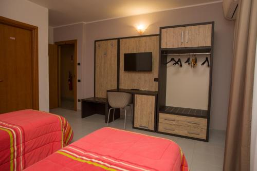リオネーロ・イン・ヴルトゥレにあるHotel San Marcoのベッド2台とテレビが備わるホテルルームです。
