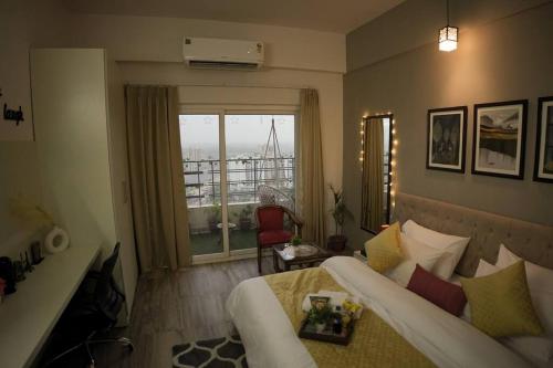 a bedroom with a bed and a window with a view at Luxury Apartment Near Pari Chowk in Greater Noida