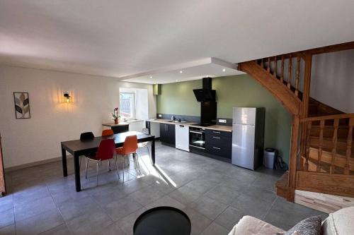 une cuisine avec une table et des chaises rouges dans une pièce dans l'établissement Maisonnette de charme, à Le Villard