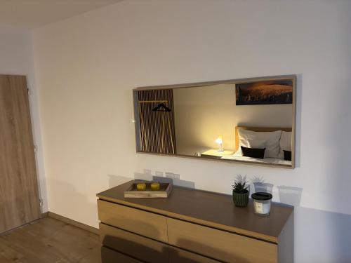 a mirror on a wall above a dresser in a room at Apartmán Centrum Komfort in Zvolen
