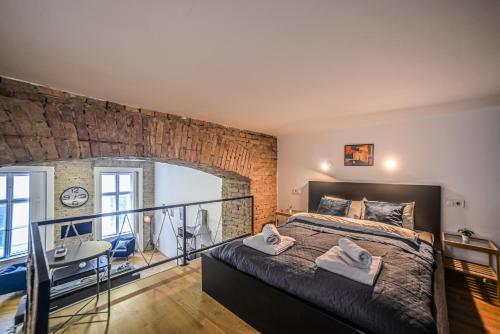 a bedroom with a large bed and a brick wall at Global Living - Dazzling Dob Dwelling in Budapest