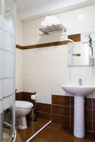 a bathroom with a toilet and a sink at Cozy apartment near Airport in Koropíon